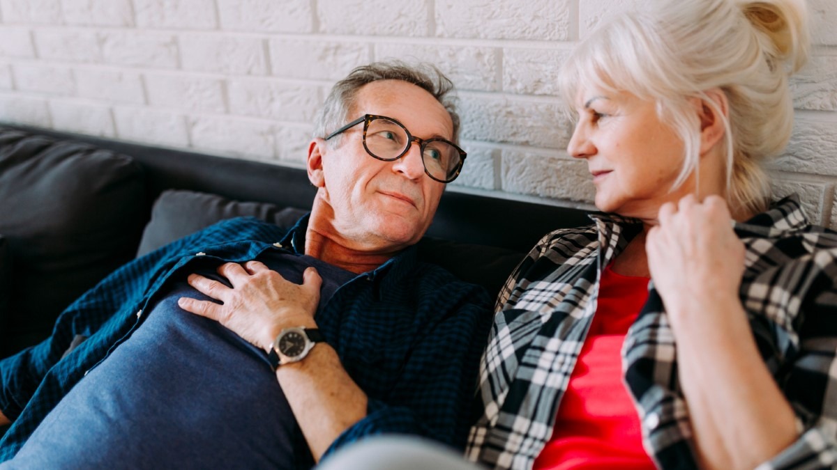 Couple senior discutant calmement à la maison, illustrant le dialogue sur l’intimité et le respect des rythmes.